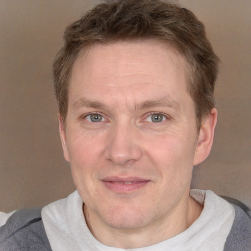 Joyful white adult male with short  brown hair and blue eyes