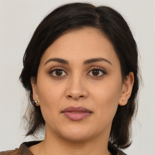 Joyful latino young-adult female with medium  brown hair and brown eyes