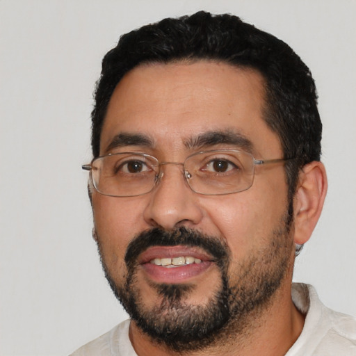Joyful latino adult male with short  black hair and brown eyes