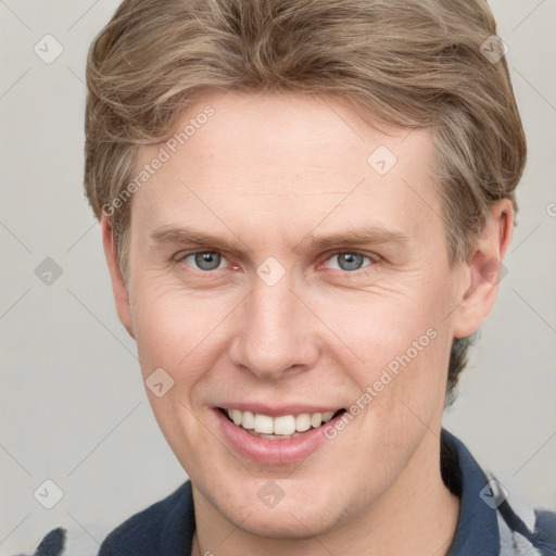 Joyful white adult male with short  brown hair and blue eyes