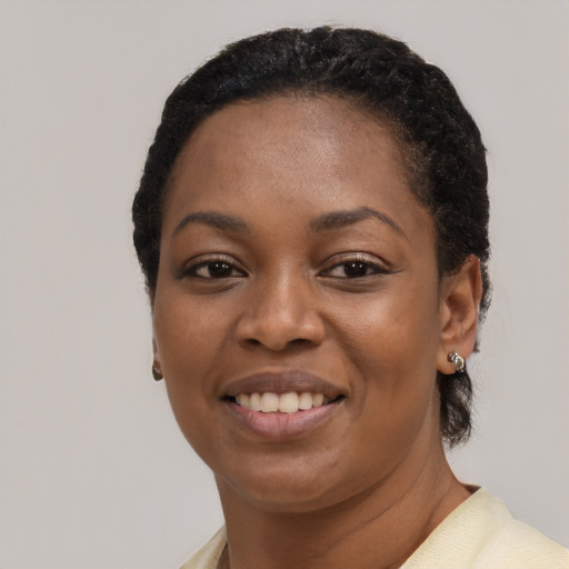 Joyful black young-adult female with short  black hair and brown eyes