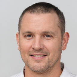 Joyful white adult male with short  brown hair and brown eyes