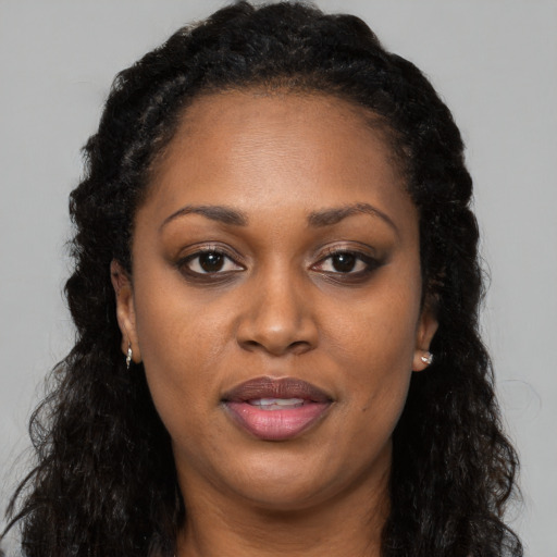 Joyful black adult female with long  brown hair and brown eyes