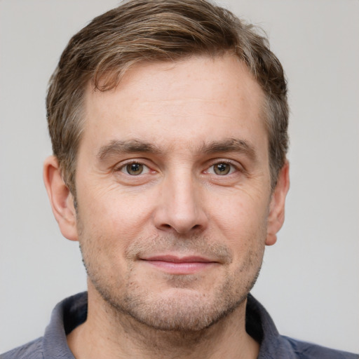 Joyful white adult male with short  brown hair and grey eyes