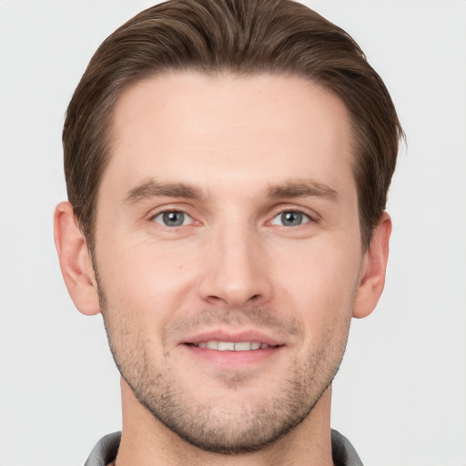 Joyful white young-adult male with short  brown hair and grey eyes