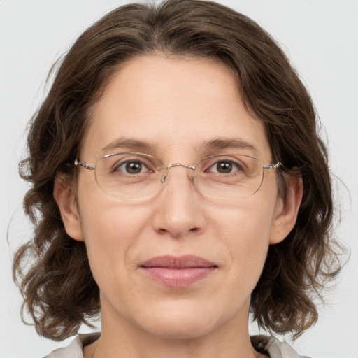 Joyful white adult female with medium  brown hair and grey eyes