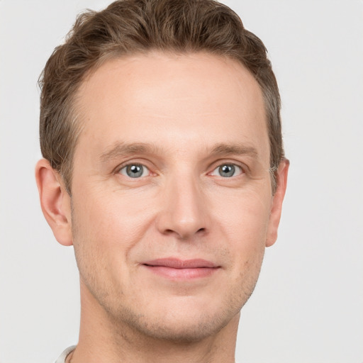 Joyful white adult male with short  brown hair and grey eyes