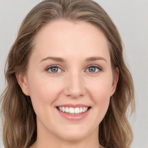 Joyful white young-adult female with long  brown hair and grey eyes