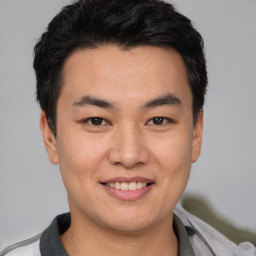 Joyful asian young-adult male with short  black hair and brown eyes