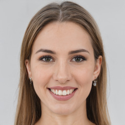 Joyful white young-adult female with long  brown hair and brown eyes