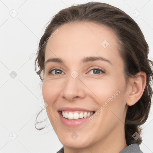 Joyful white young-adult female with medium  brown hair and grey eyes