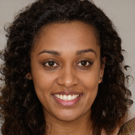 Joyful black young-adult female with medium  brown hair and brown eyes
