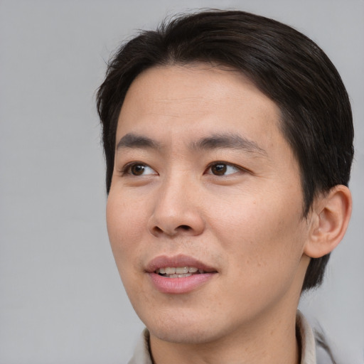 Joyful asian young-adult male with short  brown hair and brown eyes