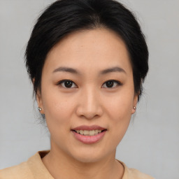 Joyful asian young-adult female with short  brown hair and brown eyes