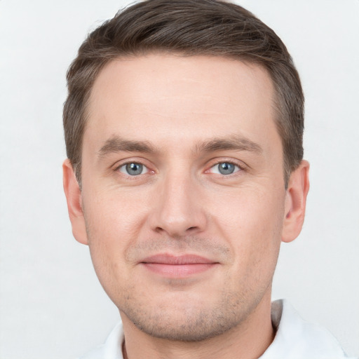 Joyful white young-adult male with short  brown hair and grey eyes