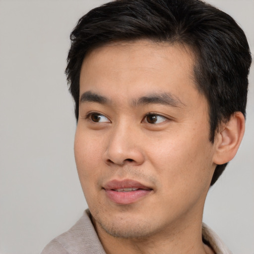 Joyful asian young-adult male with short  black hair and brown eyes