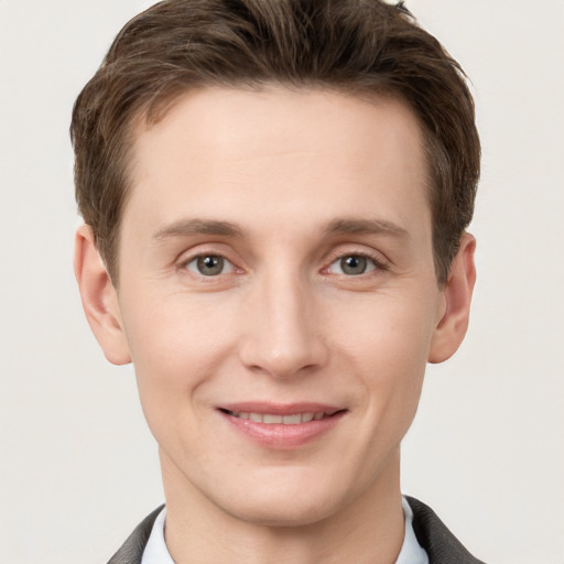 Joyful white young-adult male with short  brown hair and grey eyes