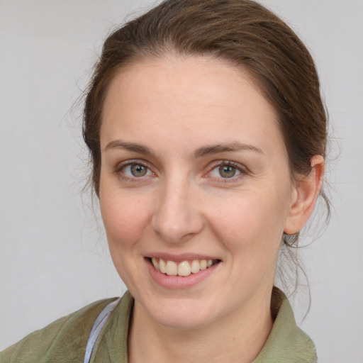 Joyful white young-adult female with medium  brown hair and grey eyes