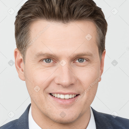 Joyful white young-adult male with short  brown hair and grey eyes