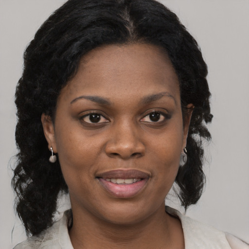 Joyful black young-adult female with medium  black hair and brown eyes