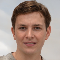 Joyful white young-adult male with short  brown hair and grey eyes