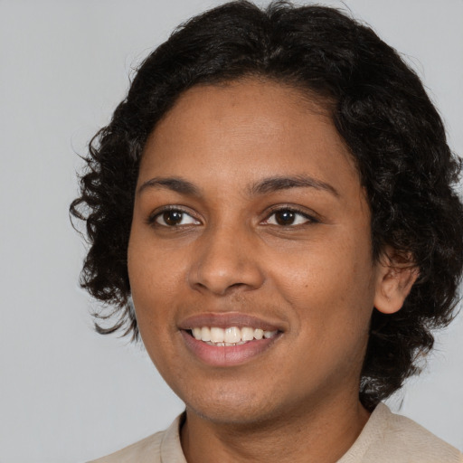 Joyful black young-adult female with medium  black hair and brown eyes