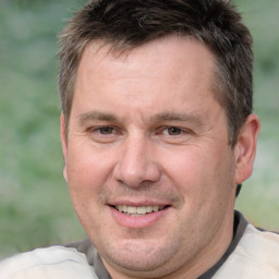 Joyful white adult male with short  brown hair and brown eyes