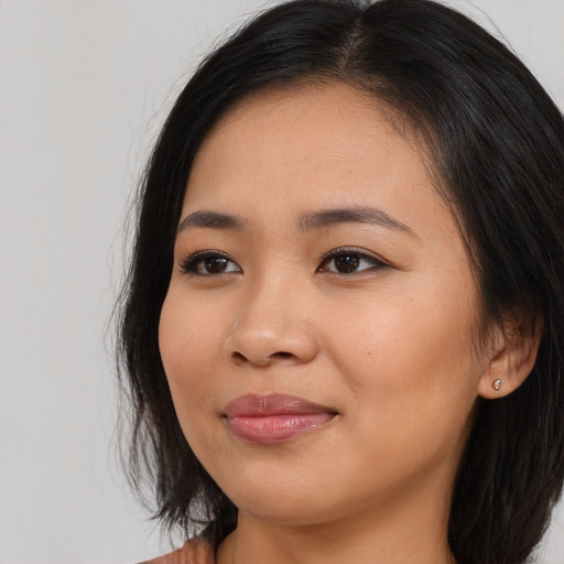 Joyful asian young-adult female with long  brown hair and brown eyes