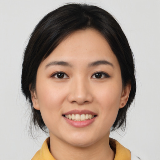 Joyful asian young-adult female with medium  black hair and brown eyes