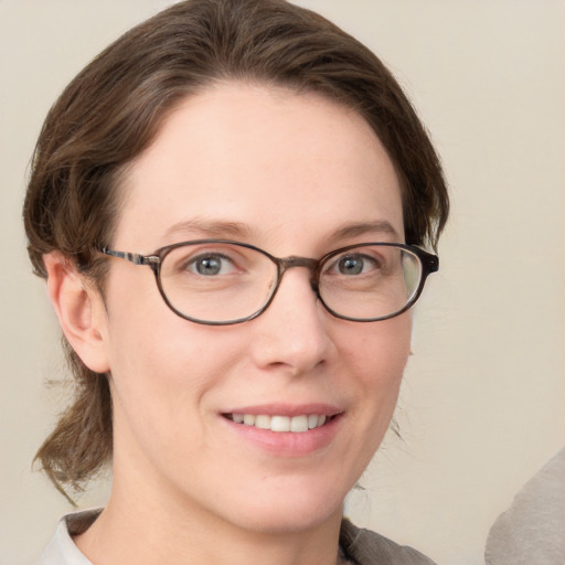 Joyful white young-adult female with medium  brown hair and grey eyes