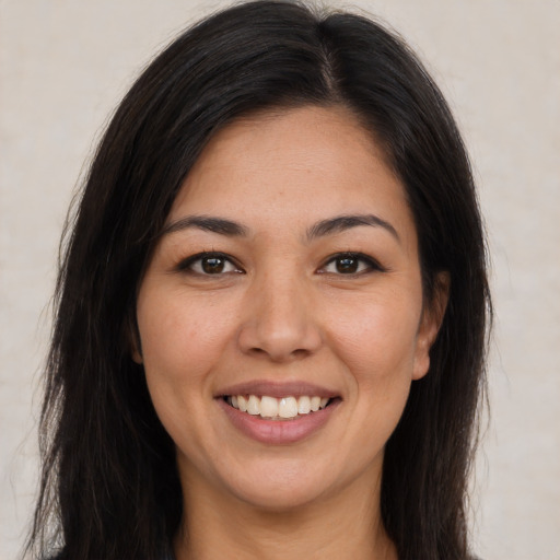 Joyful latino young-adult female with long  brown hair and brown eyes