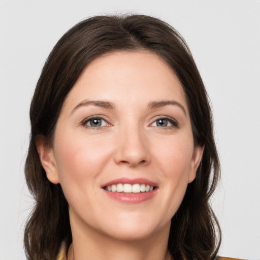 Joyful white young-adult female with medium  brown hair and grey eyes