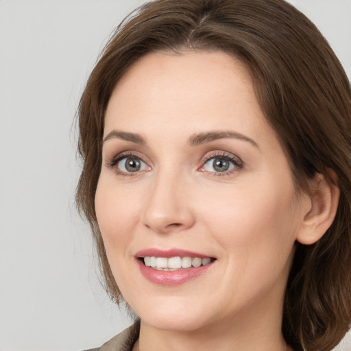 Joyful white young-adult female with medium  brown hair and grey eyes