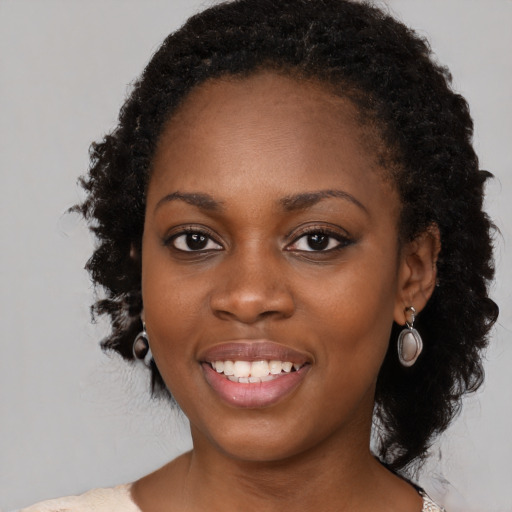 Joyful black young-adult female with medium  black hair and brown eyes