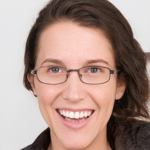 Joyful white adult female with long  brown hair and blue eyes