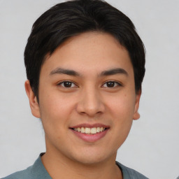 Joyful asian young-adult male with short  brown hair and brown eyes