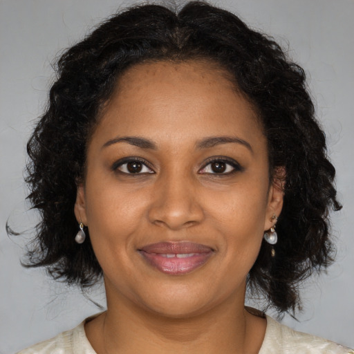 Joyful black adult female with long  brown hair and brown eyes