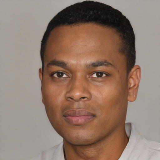 Joyful black young-adult male with short  black hair and brown eyes