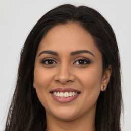 Joyful latino young-adult female with long  brown hair and brown eyes