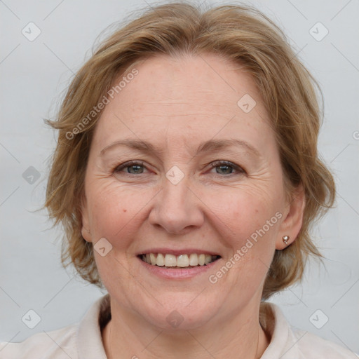 Joyful white adult female with medium  brown hair and blue eyes