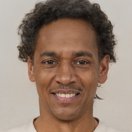 Joyful black adult male with short  brown hair and brown eyes