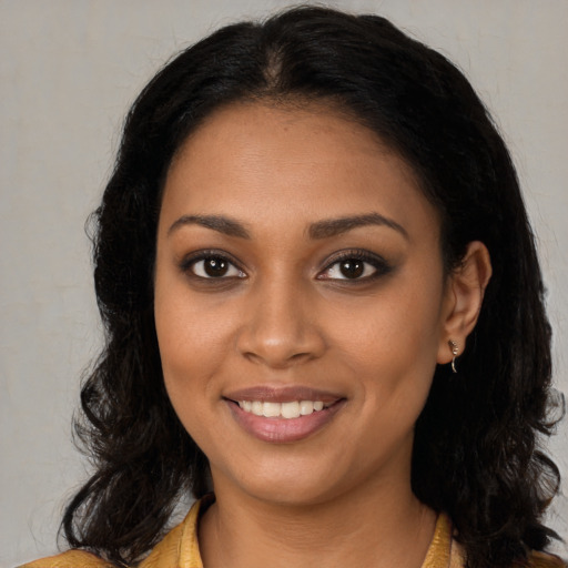 Joyful black young-adult female with long  brown hair and brown eyes