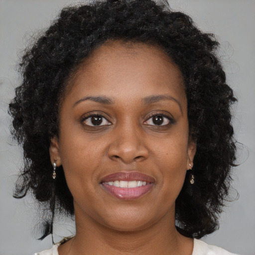 Joyful black young-adult female with medium  brown hair and brown eyes