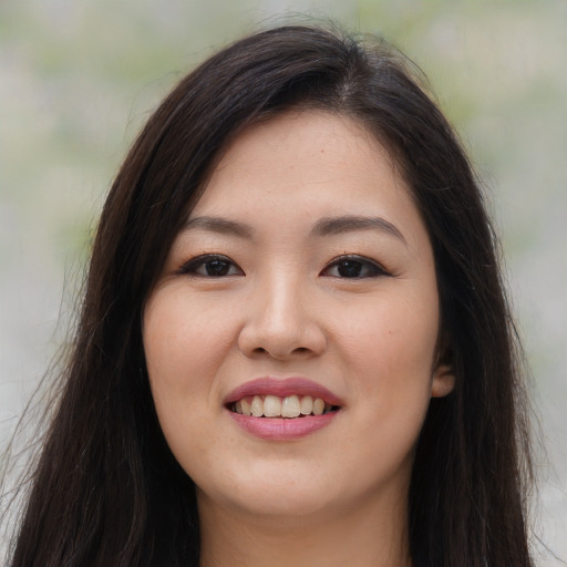Joyful asian young-adult female with long  brown hair and brown eyes