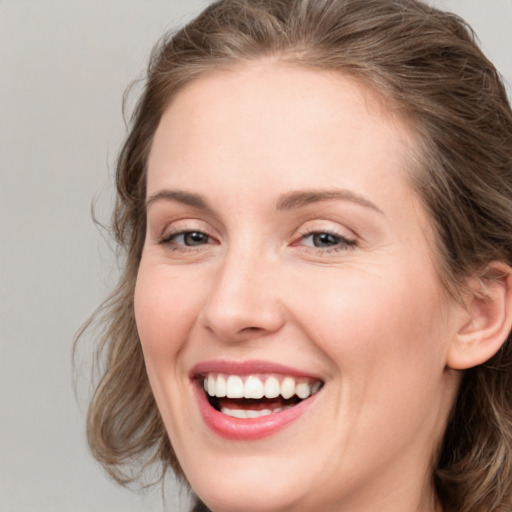 Joyful white young-adult female with long  brown hair and blue eyes