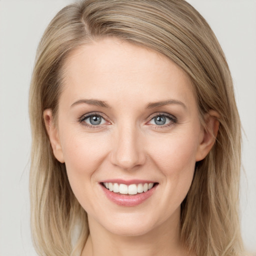 Joyful white young-adult female with long  brown hair and blue eyes