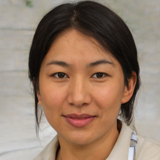 Joyful asian adult female with medium  brown hair and brown eyes