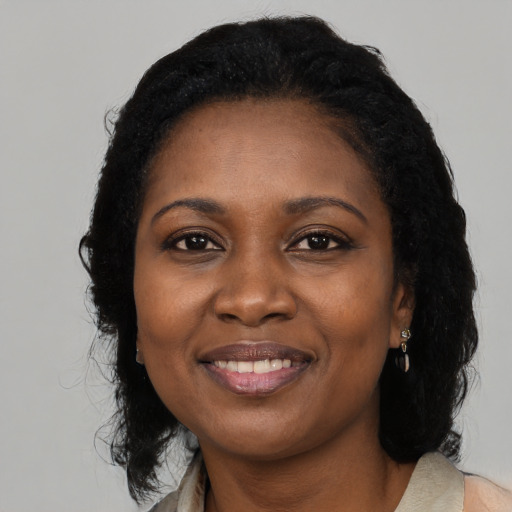 Joyful black adult female with long  black hair and brown eyes