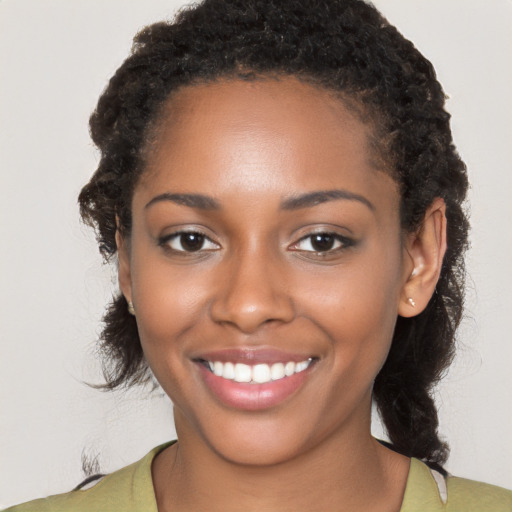 Joyful black young-adult female with long  brown hair and brown eyes