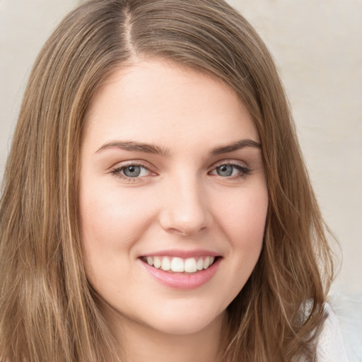 Joyful white young-adult female with long  brown hair and green eyes